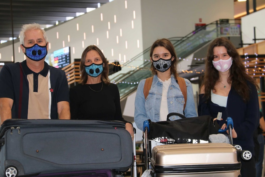 A family at Perth airport wearing air-quality masks