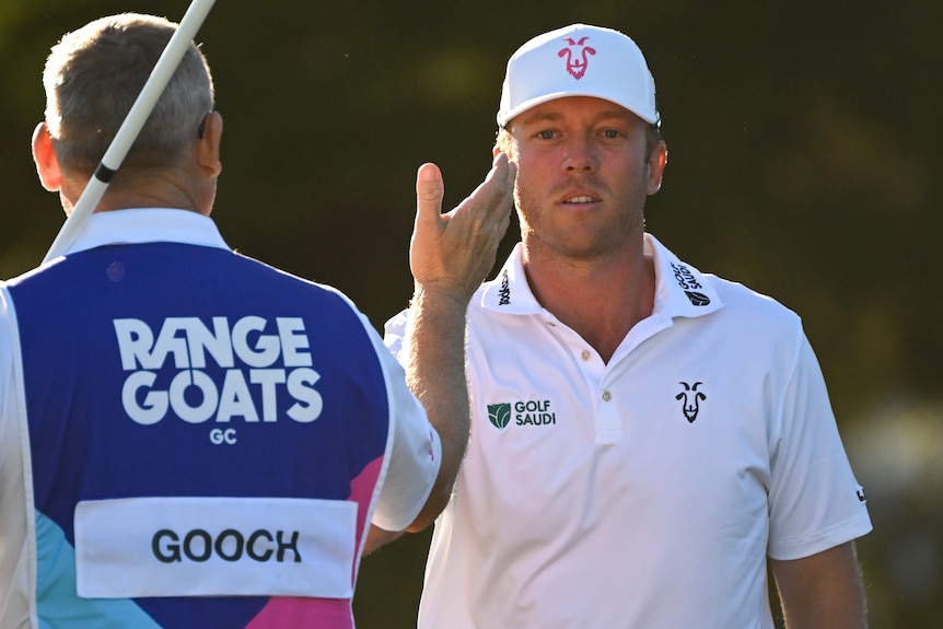 Talor Gooch high fives his caddy, seen from behind, during the LIV Golf event in Adelaide.
