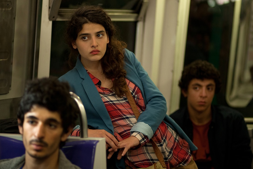 Colour still image of 3 actors in a train carriage from 2016 French film Nocturama.