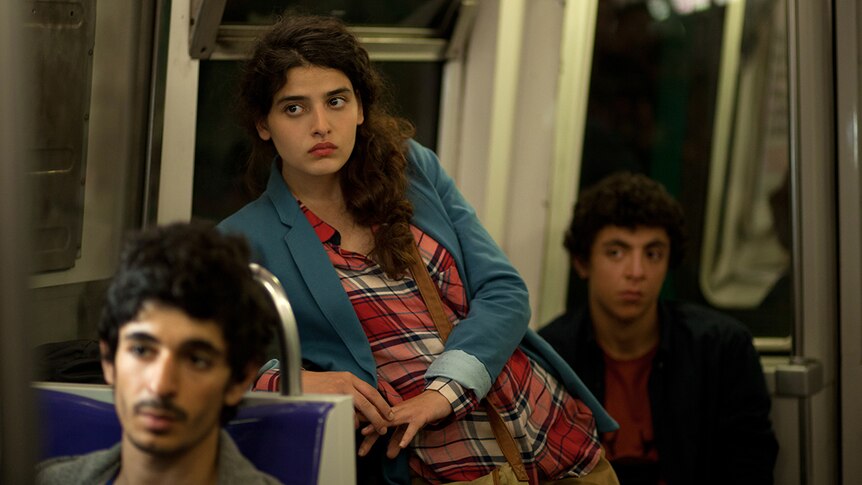 Colour still image of 3 actors in a train carriage from 2016 French film Nocturama.