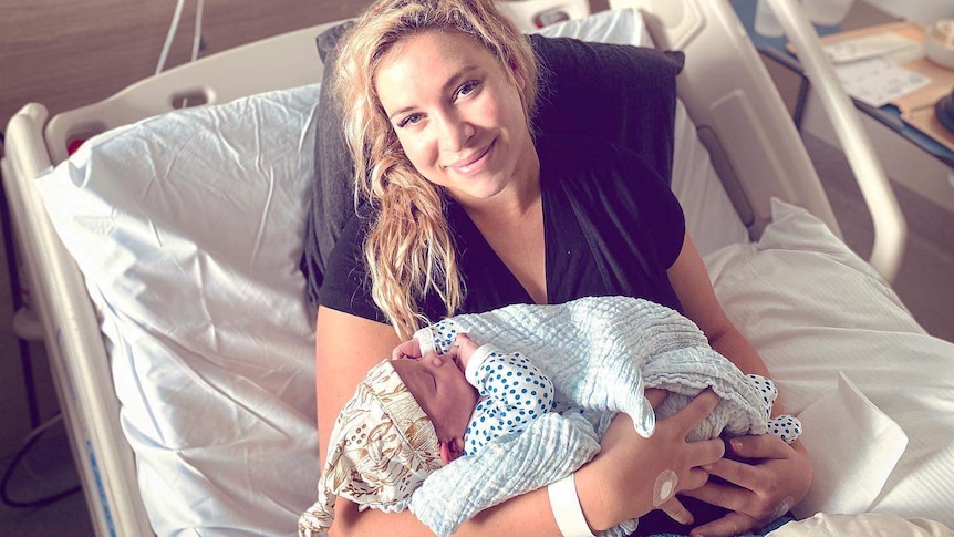 Woman with baby in hospital bed.