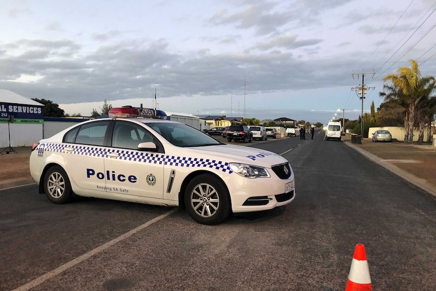 A police car on a country town road.