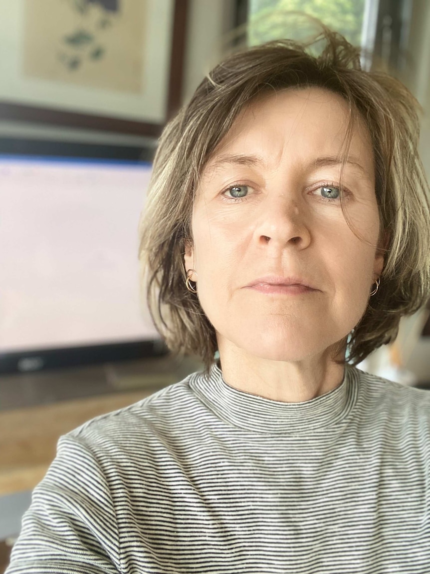 A close up of a woman wearing a black and white stripped turtleneck top