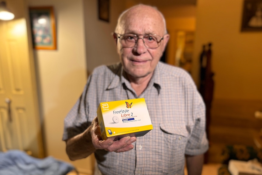 Walter Buldo holding a box containing the device he uses to monitor his diabetes.