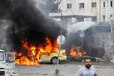 A handout picture released by the official Syrian Arab News Agency shows a flames billowing at the scene of multiple bombings in the the city of Tartus northwest of Damascus