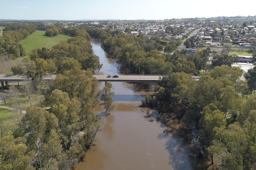 A drone shot of a river running through a regional town.