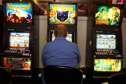 Un apostador jugando en las máquinas de póquer en un club de Sydney 