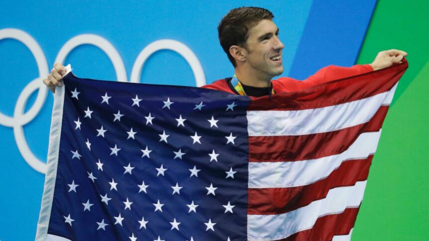 Michael Phelps holds a United States of America flag. Photo: AP