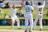 A red-faced Test bowler roars and raises his arms after taking a wicket.