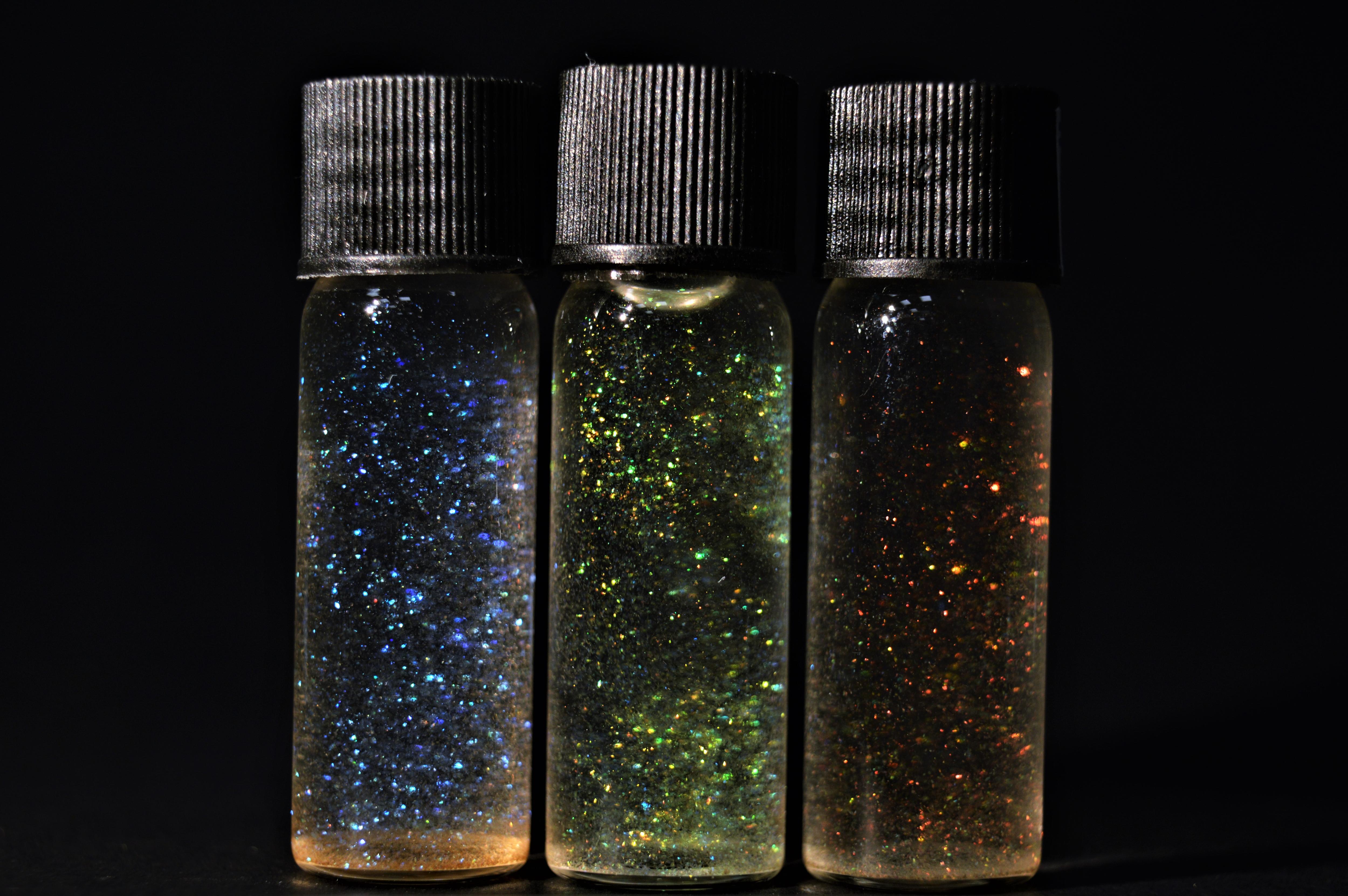 three vials of glitter in fluid