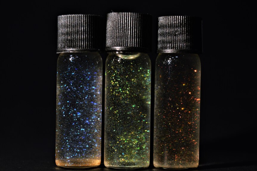 three vials of glitter in fluid