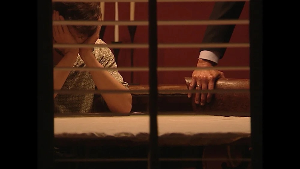 A man sits with his head in his hands.