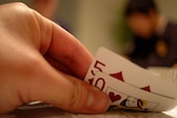 Generic picture of a poker player with a 5 of diamonds and queen of hearts.