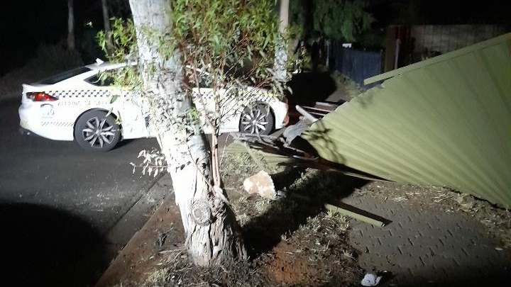 A police car with a fence fallen on it