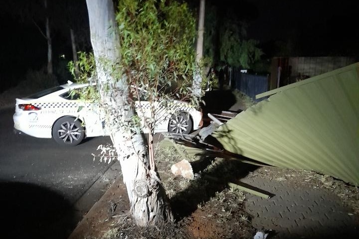 A police car with a fence fallen on it