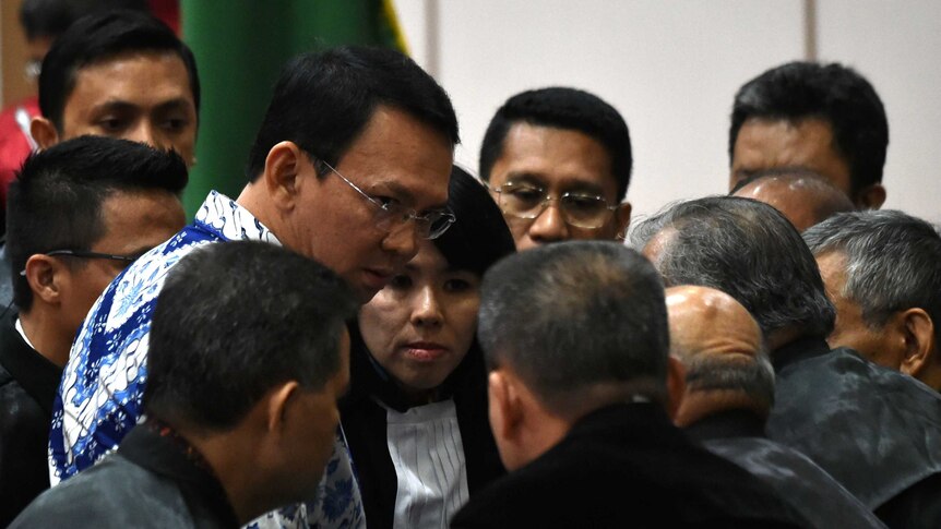 Jakarta's Christian governor Basuki Tjahaja Purnama (L), popularly known as Ahok, speaks to a ring of lawyers surrounding him.