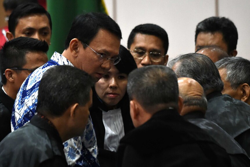 Jakarta's Christian governor Basuki Tjahaja Purnama (L), popularly known as Ahok, speaks to a ring of lawyers surrounding him.