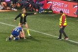 A security guard is sent away from two players on the pitch after he rushes over to help separate them