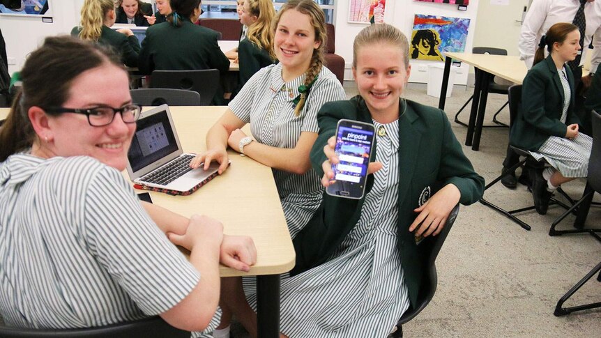 Clayfield College Year 11 student Stephanie Jensen holds out her team's app PinPoint