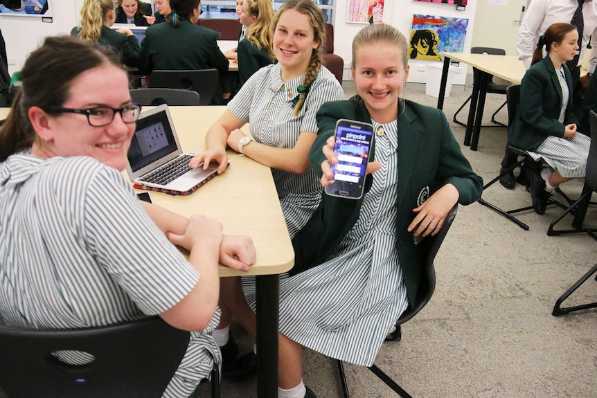 Clayfield College Year 11 student Stephanie Jensen holds out her team's app PinPoint