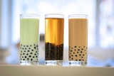 Close up of three glasses with colourful liquid inside them