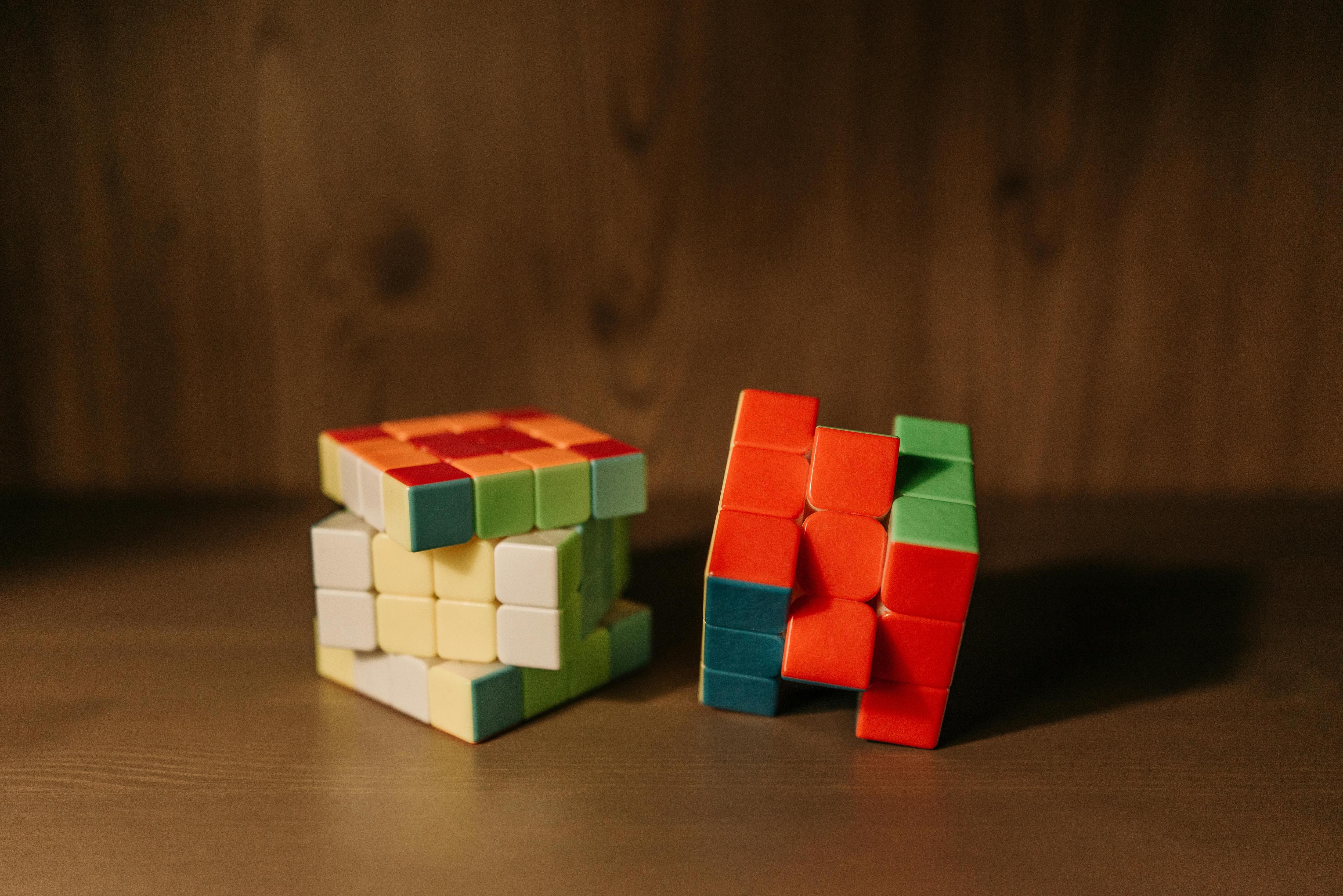 Two partially solved Rubiks cubes on a table