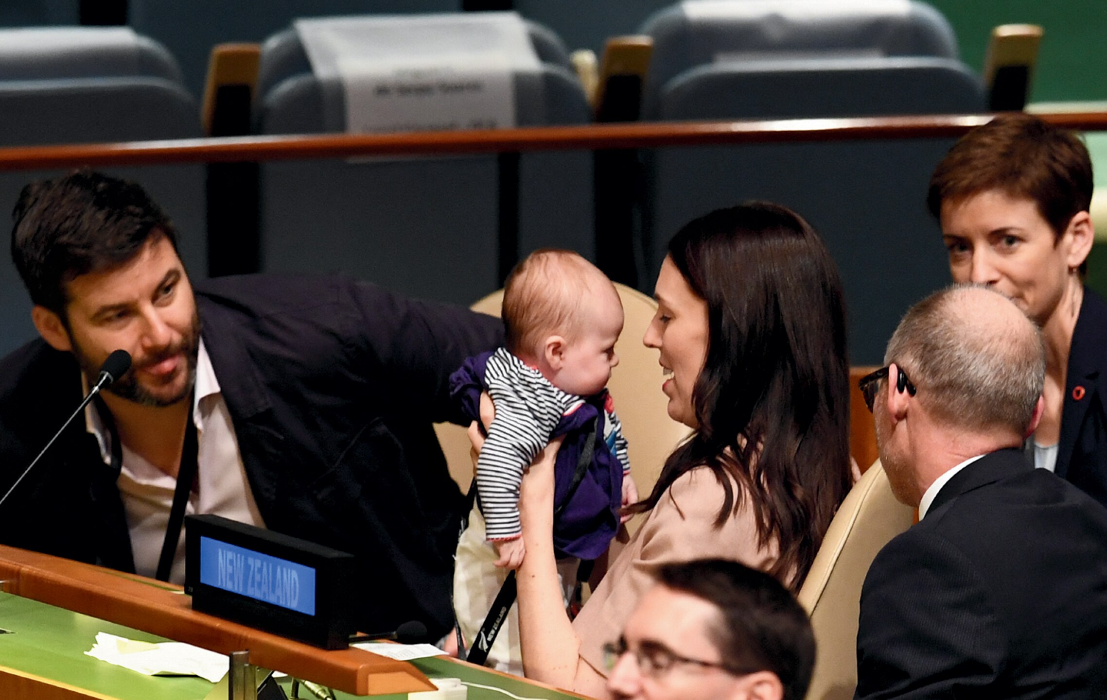 A woman holds a baby at the United Nations as others watch on.