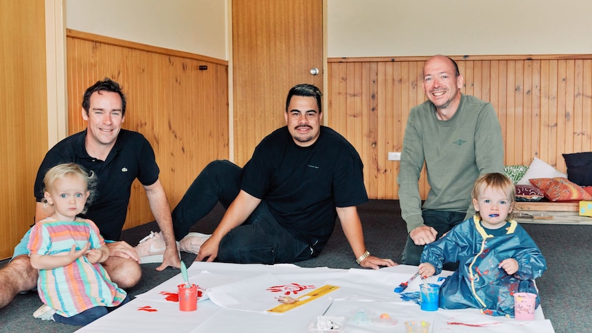three men, two children smiling at playgroup 
