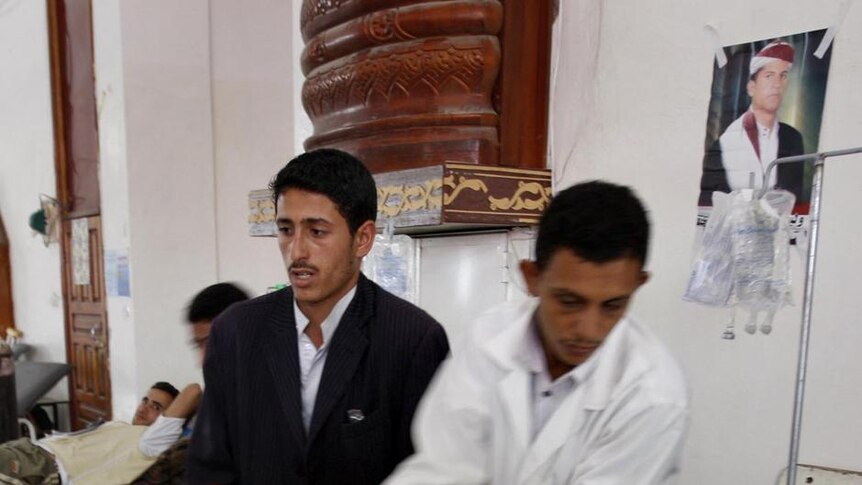 A wounded Yemeni dissident tribesman is moved from a stretcher to a bed at a makeshift clinic