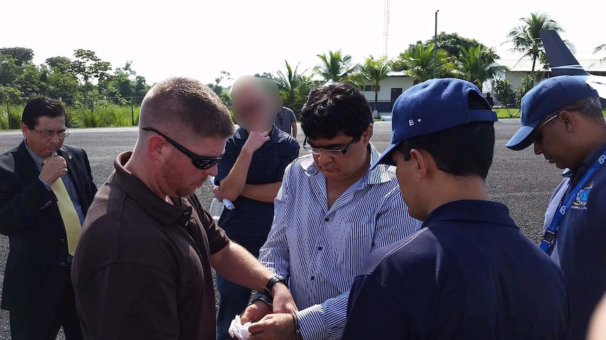 DEA agent places handcuffs on the wrists of Abdul Sattar Khanani.