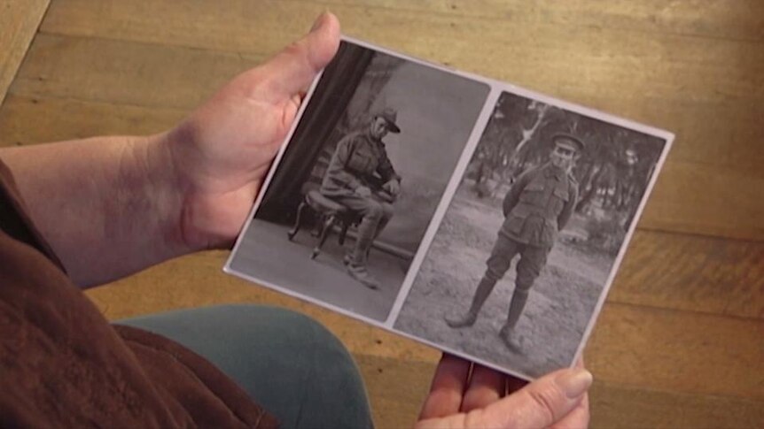 Hands hold portrait photo of two soldiers in uniform