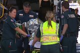 Injured man taken off ambulance, after plane crash on Perth oval