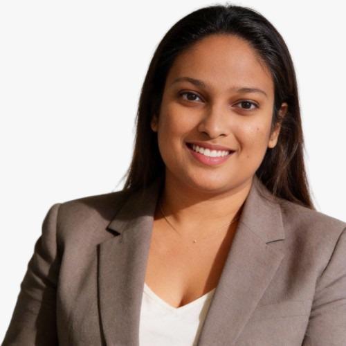 A woman with long brown hair wears a brown blazer.