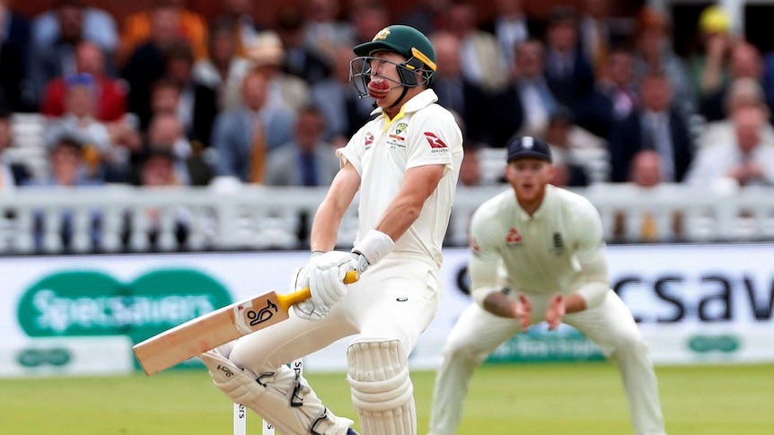 Marnus Labuschagne rocks back as a cricket ball collides into his helmet's grill