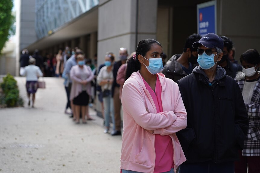 People with masks lined up outside the centre.