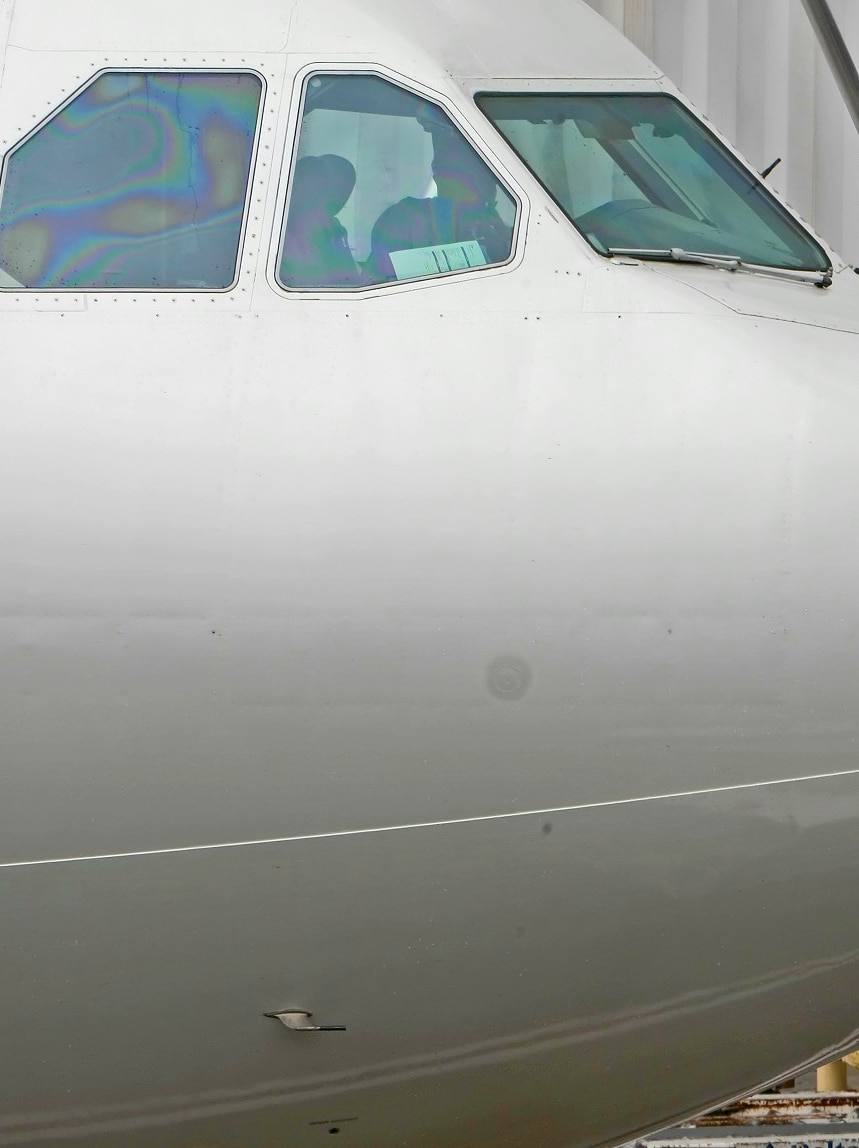 A white passenger plane, showing the cockpit and a small metal tube below