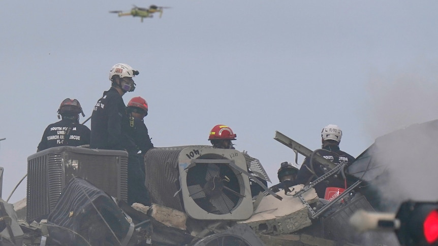 Search and rescue personnel search for survivors through the rubble with the aid of a drone.