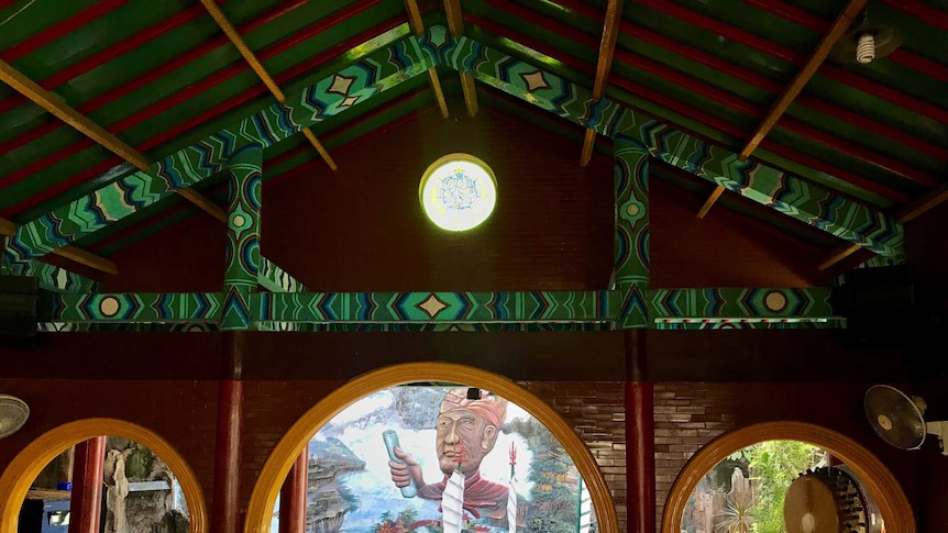 The inside of a colourful mosque looks out to a mural of Cheng Ho and his ship.