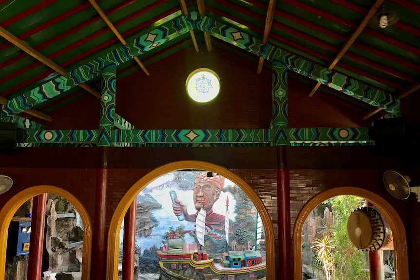 The inside of a colourful mosque looks out to a mural of Cheng Ho and his ship.