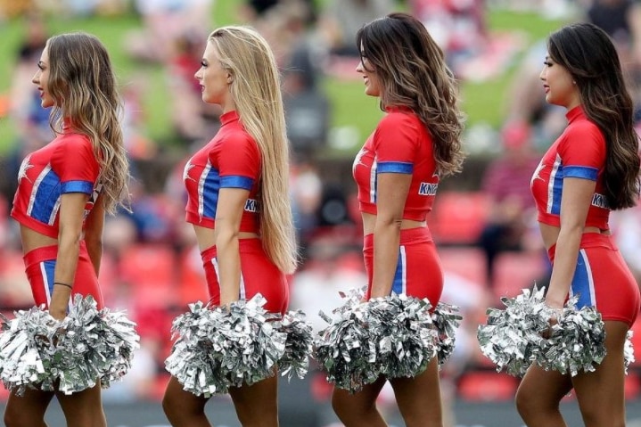 Cheerleaders at a Knights game, dressed in red, with pom-poms.