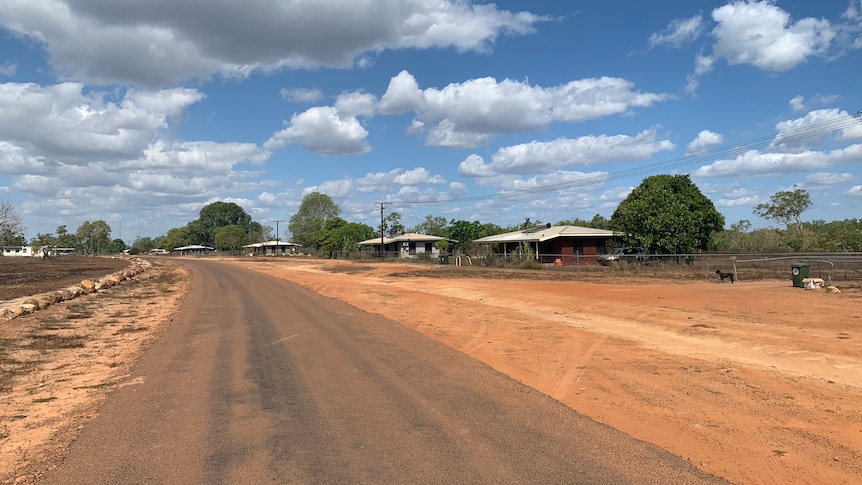 A red dirt road with the Peppimenarti community in the background.