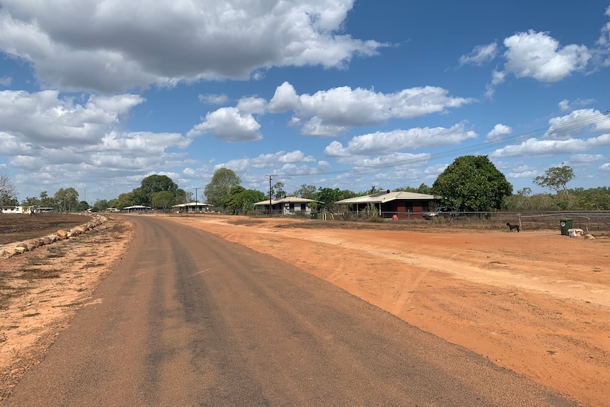 A red dirt road with the Peppimenarti community in the background.