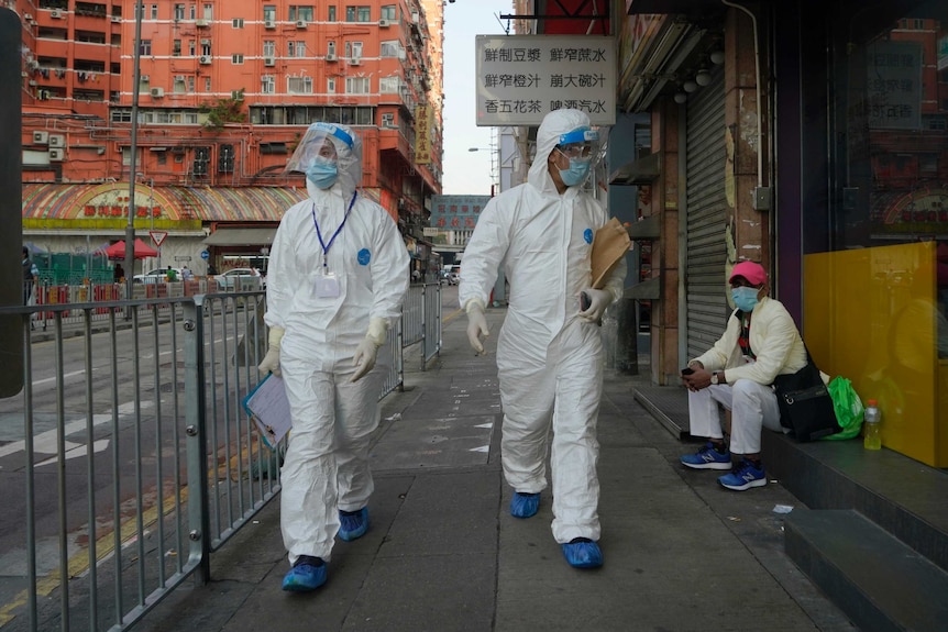 身穿防护服的政府调查人员，走在香港油麻地地区