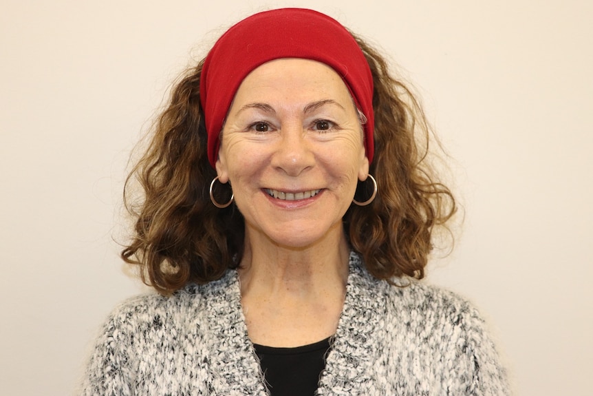 Close up of a woman wearing a head band smiling at the camera