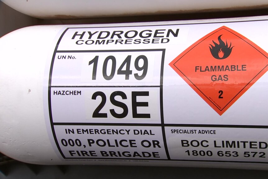 A hydrogen container with a warning sign about flammable gas. 