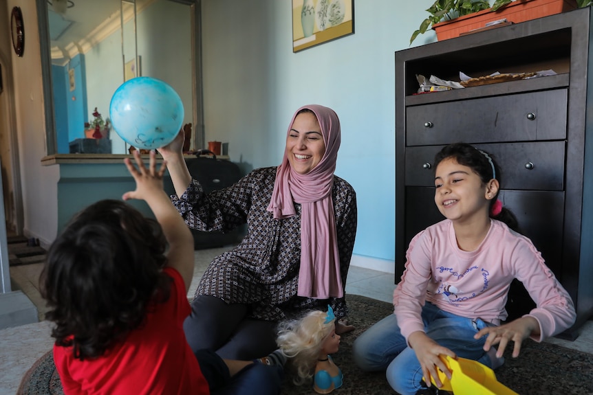 A young plays with her two children