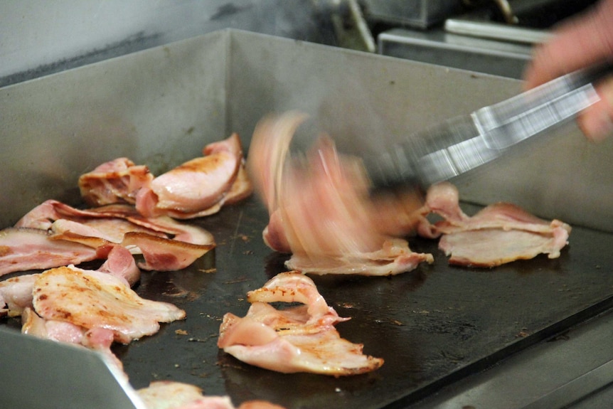 Bacon being cooked on a hotplate