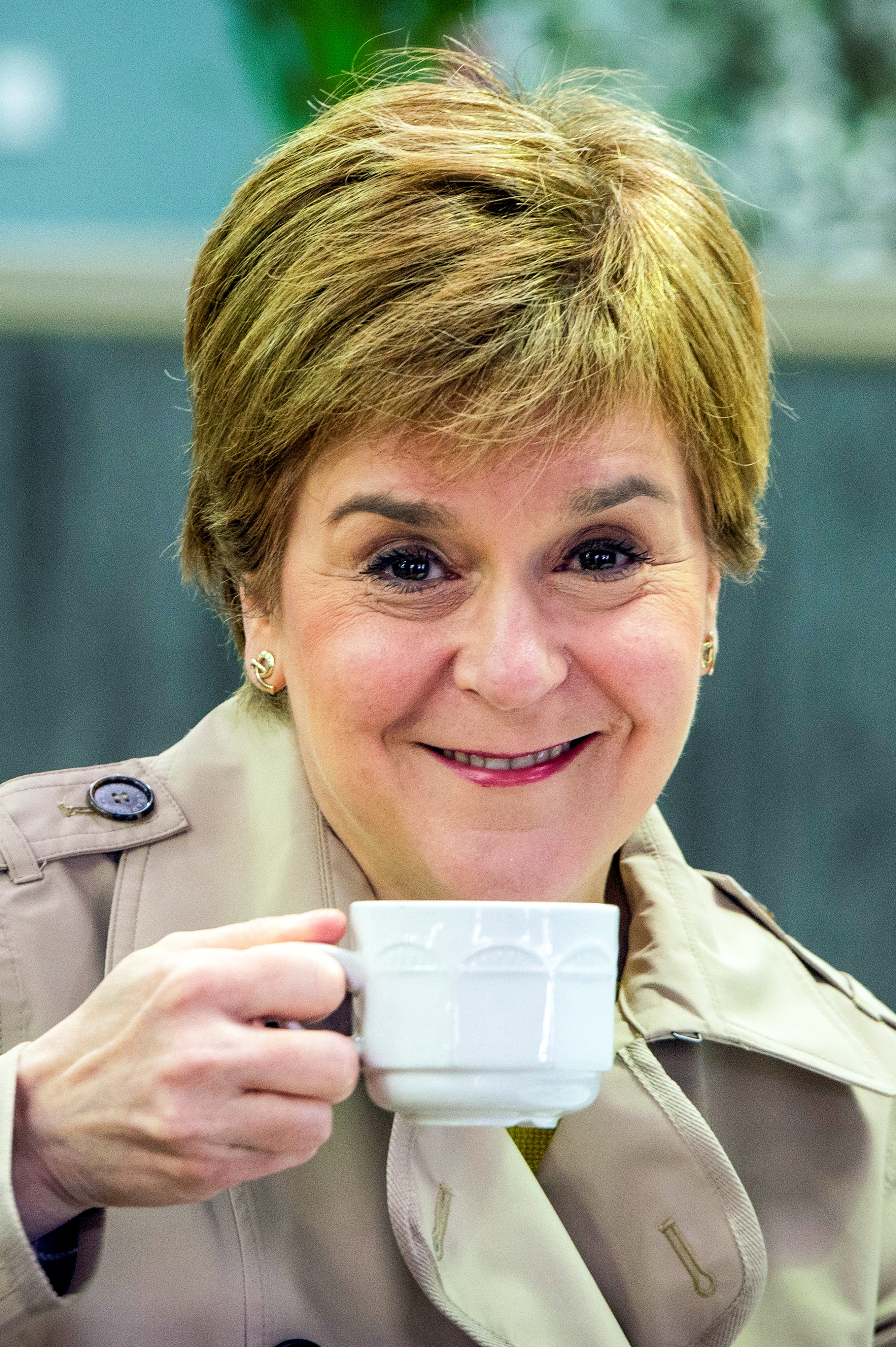 Nicola Sturgeon smirks while holding a tea cup 