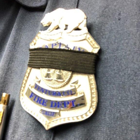 A black band is seen around a firefighters badge