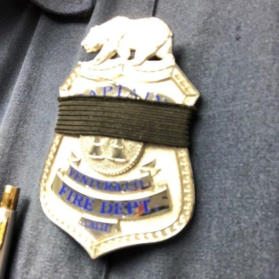 A black band is seen around a firefighters badge